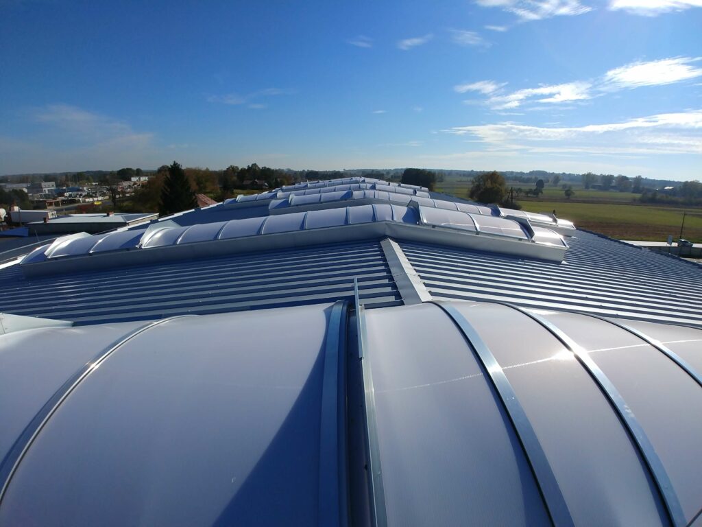 Generalne wykonawstwo PRB UNIMA — dach hali przemysłowej z systemem świetlików i konstrukcją stalową.